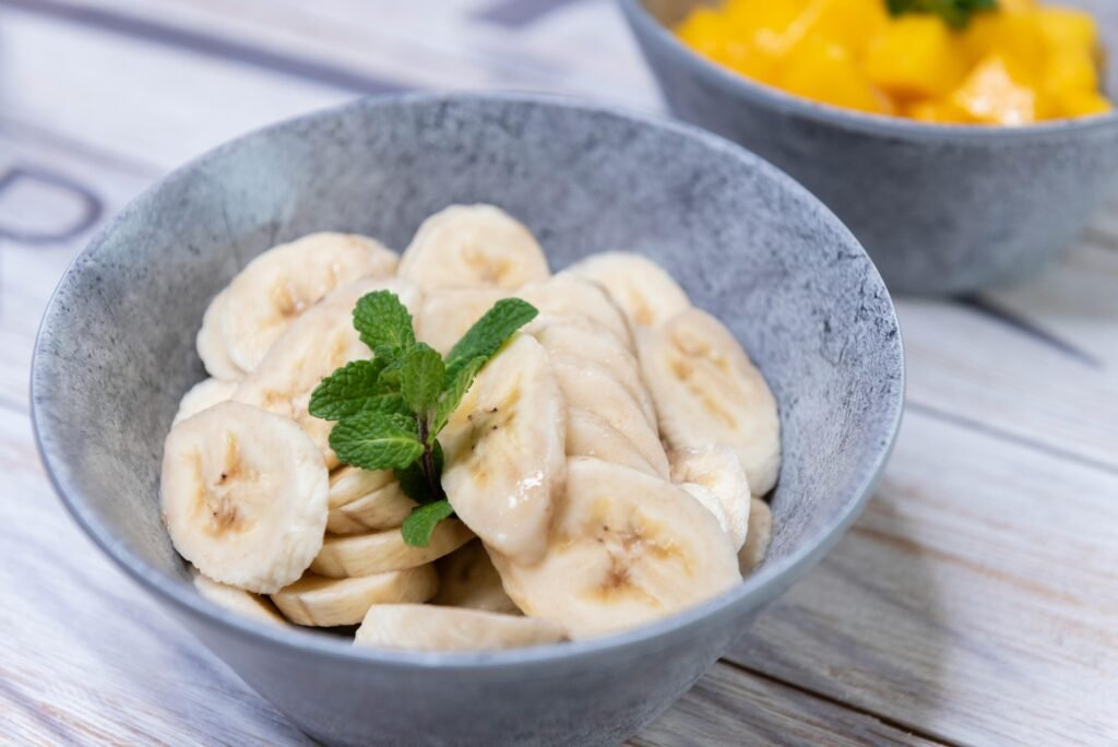 Close-up of fresh banana slices garnished with mint leaves in a grey bowl on a wooden table.
Brighten up your plate with this refreshing banana salad, a unique and flavor-packed fruit dish that brings together the natural sweetness of ripe bananas with a zesty citrus twist. Perfect as a light dessert, side dish, or even a fun brunch addition, this easy-to-make salad is both wholesome and satisfying. Tossed with honey, a squeeze of lemon or lime, and a sprinkle of nuts or seeds, it offers the perfect balance of creamy, tangy, and crunchy textures. Whether served chilled on a summer day or added to a festive spread, this healthy fruit blend is a simple, feel-good recipe that everyone will love.

